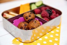 a metal container filled with fruit and muffins