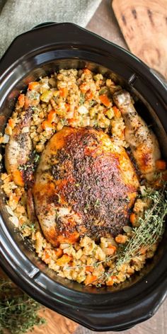 a slow cooker filled with chicken and rice, garnished with fresh herbs