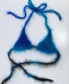 a piece of blue and white yarn on top of a white surface