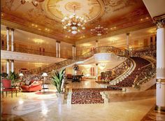 an ornately decorated lobby with stairs and chandelier