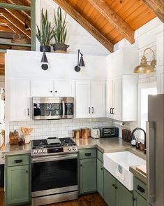 a kitchen with green cabinets and white walls