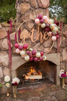 an outdoor fireplace decorated with balloons and streamers that say gather on the sign above it