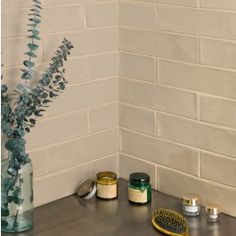 the corner of a bathroom with various items on the counter