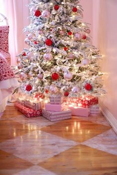 a white christmas tree with presents under it