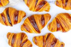 croissants are arranged on a marble surface