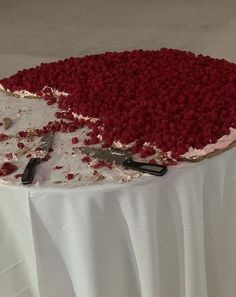 there is a cake with red and white frosting on the top, sitting on a table