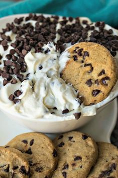 chocolate chip cookies and whipped cream in a white bowl on a plate next to some cookies