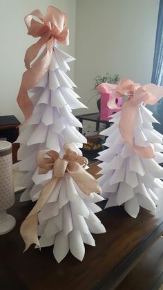 three paper christmas trees with bows on them