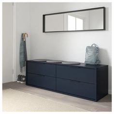 a blue dresser sitting next to a mirror and coat rack