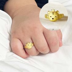 a person's hand with two gold rings on top of their fingers, and the image of a teddy bear