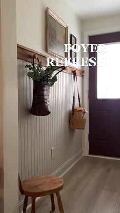 a wooden bench sitting in front of a door with a plant hanging on the wall