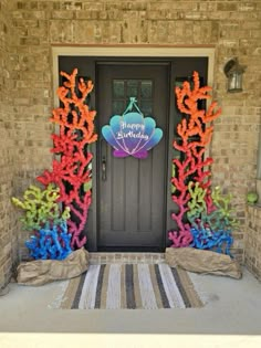 a front door decorated with balloons and streamers for a happy birthday party in the shape of seahorses