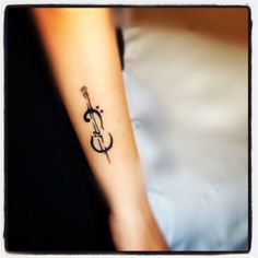 a woman's arm with a violin tattoo on the left side of her wrist