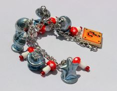 a bracelet with an orange pacman charm on it