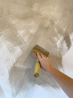 a person using a brush to paint a wall