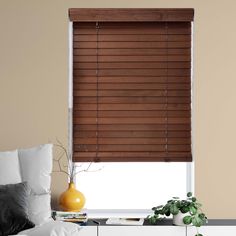 a living room with a white couch and brown blinds