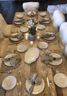 the table is set with white plates and silverware, along with other place settings