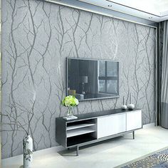 a living room scene with focus on the entertainment center and wall papered in silver