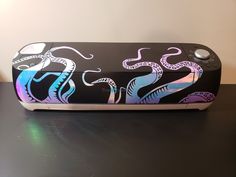 a black and purple box with an octopus on it's lid sitting on a table