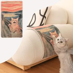 a cat standing next to a couch with a painting on it's back end