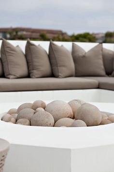 a white table with some rocks in it and pillows on the back wall behind it