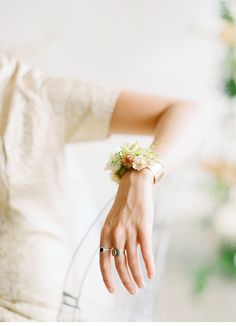 a close up of a person's hand wearing a bracelet with flowers on it