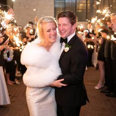 a bride and groom are surrounded by sparklers