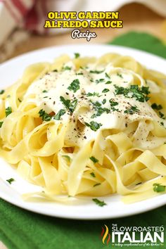 a white plate topped with pasta covered in cheese and parsley on top of a green place mat