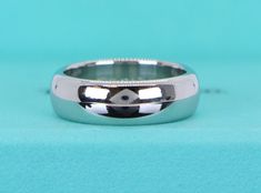 a close up of a wedding ring on a blue surface with a black and white design