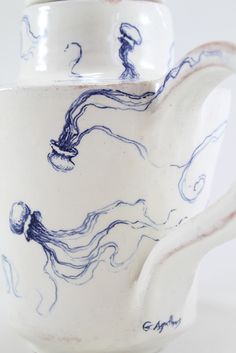 a blue and white tea pot with an octopus on it's side is shown