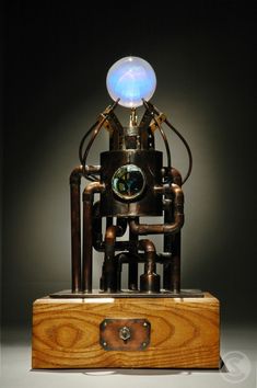 a sculpture made out of metal and wood with a light bulb on top of it