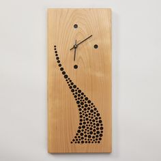 a wooden clock with a woman's face on it and black dots in the design