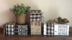 three books are stacked on top of each other with a potted plant next to them