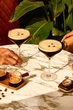 three glasses of wine on a table with buttons in the middle and coffee beans around them