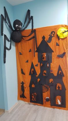 a room decorated for halloween with decorations on the walls and a spider hanging from the wall