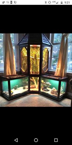 a fish tank is shown in the middle of a room with windows and curtains on it