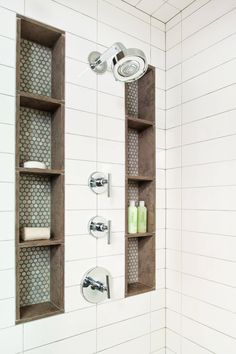 a bathroom with white tile and wooden shelves on the wall, along with two shower heads