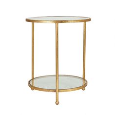 the side table is gold and has a glass shelf on one end with two shelves