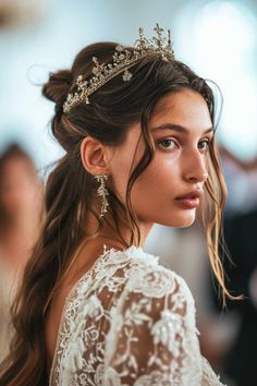 a woman with long hair wearing a tiara and veil, looking off to the side