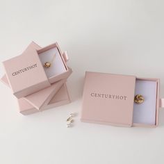 two pink jewelry boxes sitting next to each other