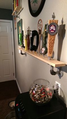 there are many items on the shelf above the bowl that is filled with beer cans