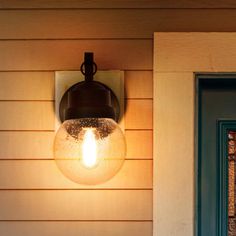 a light that is on the side of a house next to a door and window