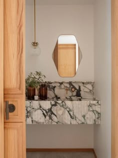 a bathroom with a marble counter top and wooden door handle on the left hand side