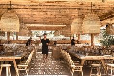 a man standing in the middle of an outdoor dining area with tables and stools