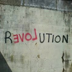 graffiti on the side of a building that says revolution written in red and black ink