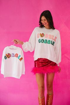 Show off your holiday spirit with this GOBBLE GOBBLE White Pullover! This lightweight cropped top is sure to get you in the Thanksgiving mood with its pink and green sequin Gobble Gobble text, and a feathered turkey patch sure to put a smile on your turkey-lovin' face. Feel cozy and festive all at once! Gobble 'til you wobble! This is a made-to-order item. All customized orders are currently shipping within 14 business days. To receive item quicker, expedited shipping is available at checkout. S White Fun Sweater For Fall, Fun White Sweater For Fall, Gobble Til You Wobble, White Pullover, Gobble Gobble, Green Sequins, White Design, Cropped Top, Holiday Spirit