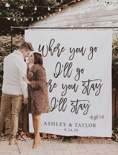 a man and woman kissing in front of a sign that says, where you go we'll go are you stay