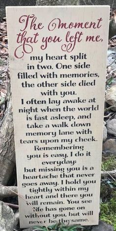 a wooden sign that says the moment that you lift me, in front of some rocks