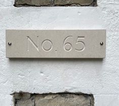 a sign on the side of a building that says no 65 in english and spanish