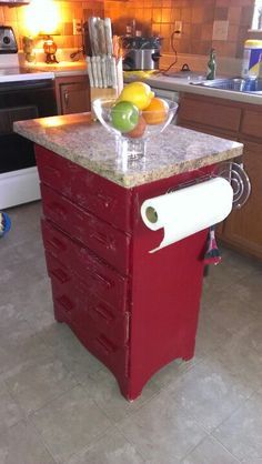 a kitchen island made out of an old cart with fruit on top and paper roll in the middle